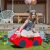 Lány az IGLU Soft Play piros autó hintán, szabadtéri születésnap