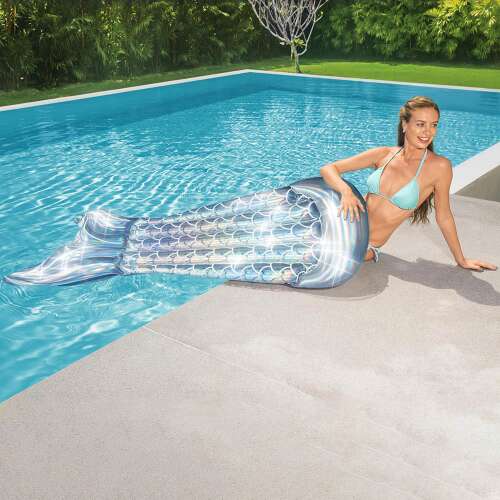 Woman relaxing on Bestway mermaid tail pool float by the pool.