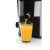 Eta Fresher II juicer, black and silver, pouring juice into a glass