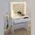 White dressing table with mirror and lights, showing the table in a room