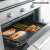 Non-stick heat-resistant baking sheet for oven and grill, salmon and vegetables on the sheet in the oven