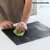 Non-stick heat-resistant baking sheet for oven and grill, person cleaning the sheet with a cloth