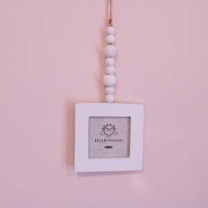 Fehér négyzet alakú képkeret Heartwood logóval, fehér fa gyöngyökkel lógva, kis képekhez - Képkeret