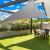 Gray triangle shade sail providing shade over a patio.
