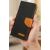 Xiaomi Redmi 13 fekete vászon pénztárca tok barna bőr díszítéssel és mágneses záródással, kézben tartva, ferde nézet