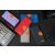 Több színű vászon pénztárca tok Xiaomi Redmi Note 15 Pro 5G telefonhoz (lila, piros, kék, szürke, sötétkék) elrendezve egy sötét asztalon könyvvel és tollal, bemutatva a választékot.