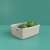 Beige Jute storage basket with handles, filled with fruits, on a green background