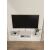 Toby Tv Stand White 115 cm, falra szerelve egy modern nappaliban, televízióval, médialejátszóval és kis növényi dekorációval