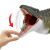 Közelkép a Jurassic World Szuper Kolosszális Mosasaurus akciófigura szájáról, egy kis dinoszaurusz figurát mutatva, amelyet 'megtámad', és egy kezet, amely a mozgatható állkapoccsal interakcióba lép