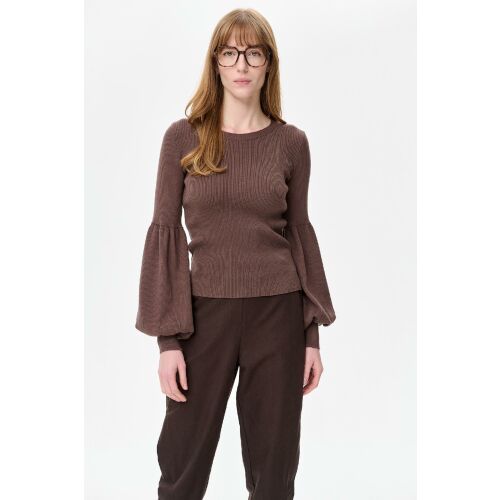 Sweter Damski Exi Light Chocolate pulóver 40/42 méretben, közeli felvétel egy nőről, aki csokoládébarna kötött pulóvert visel széles hosszú ujjakkal, kiemelve az anyag textúráját és illeszkedését - Női pulóver