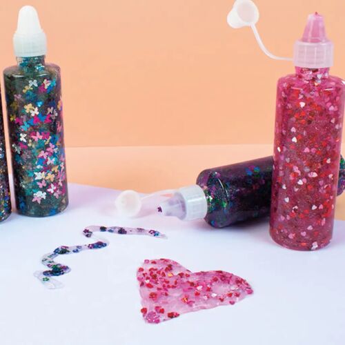 PlayBox Glitteres ragasztó szett 6db-os, közelkép három flakon csillogó ragasztóról színes konfetti formákkal, kinyomott ragasztóval, ami szívet és örvényeket formáz, ideális kreatív projektekhez - Ragasztó
