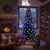 Gyerekek csodálnak egy karácsonyfát MORE&DECO SMART 200 LED többszínű fényfüzérrel díszítve, meleg és hideg színekkel, egy hangulatos nappaliban kandallóval
