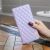 Kézben tartott Wooze Pillow lila steppelt oldalra nyíló tok iPhone 15 Plus-hoz, 3D rombusz mintás textúrát mutatva