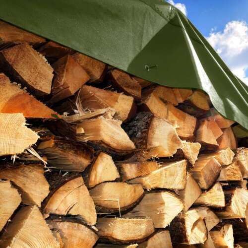 Grüne Polyethylenplane, die einen Holzstapel bedeckt