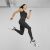 Teljes alakos kép egy nőről PUMA TOP EVERSCULPT BEÉPÍTETT 52391801 L-ben és fekete leggingsben, atletikus pózban ugorva