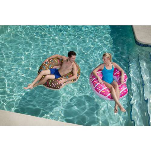 Zwei Personen entspannen sich auf einem Donut-Schwimmring, einem rosa und einem braunen, in einem Schwimmbad