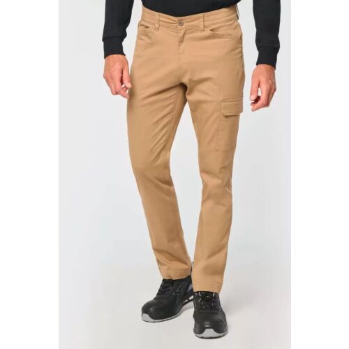 Egy személy viseli a Designed To Work WK709 UNISZEX PAMUT STRETCH NADRÁG 58-at eltérő színben, világosbarna pamut sztreccs munkásnadrágot, bemutatva az illeszkedést és a stílust - Munkásnadrág