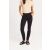 Nő visel So Denim SD025 Lily Skinny Chino nadrágot fekete színben, bézs pólóval és fekete szandállal kombinálva, termék használatban