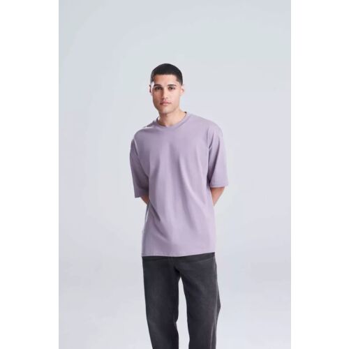 Férfi modell visel egy levendula színű Just Ts JT009 OVERSIZE 100 pólót, bemutatva az oversized szabást és az alkalmi stílust, mindennapi viseletre alkalmas. - Férfi póló