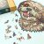 Ferdeszögű nézet a részben összeállított Shih Tzu fa kirakóról, számos kutya alakú darabbal elrendezve, és a kirakó doboza látható a háttérben.