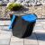 EcoBox 1 kék hulladékválogató kuka, 25L, kültéren, térkövezett felületen, háttérben sziklákkal és bokrokkal