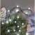 Emos D5AC06 80 LED cool white cherry ball string lights decorating a Christmas tree.