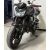 Fekete Kawasaki Z750 motorkerékpár OSK Gymkhana bukókerettel felszerelve, elölnézet egy garázsban