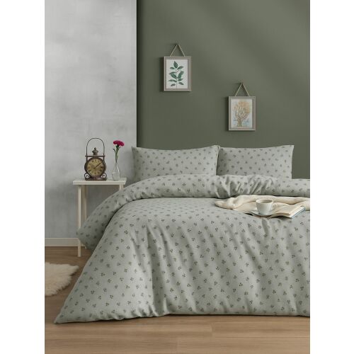 Az L'essential Maison Double Duvet Cover Set Green Olive egy nyugodt hálószobában berendezve, az ágyon a zöld levélmintás paplanhuzattal és két hozzá illő párnahuzattal, sötétzöld fal előtt. - L'essential Maison