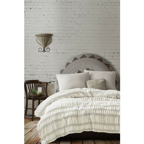 L'essential Maison Double Pique Cream Apollo ágytakaró, teljes nézet ágyon rusztikus hálószobában, krémszínű texturált csíkokkal, 100% pamut, elegáns és kényelmes - Ágytakaró