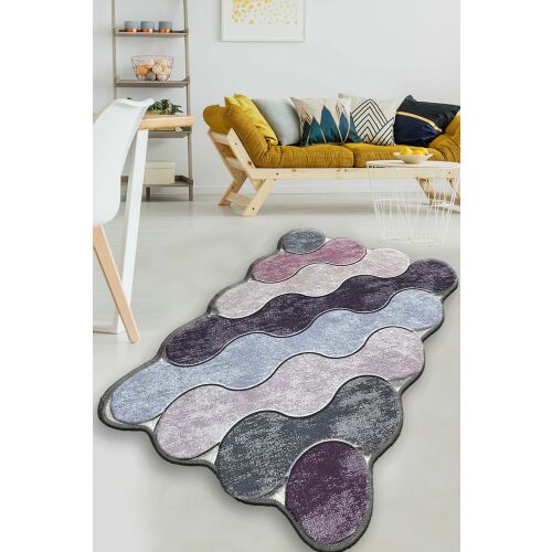 L'essential Maison Fürdőszőnyeg Lila Szürke Lilac Kör, egy puha 100% poliészter fürdőszőnyeg lila, szürke és lila árnyalatokban, hullámos mintával, egy világos padlón elhelyezve egy modern nappali környezetben - L'essential Maison