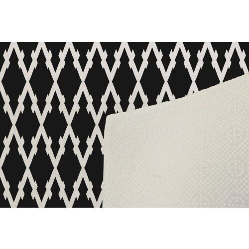 A Conceptum Hypnose szőnyeg (80 x 120) Multicolor Exfab270 részlete, amely a szélét és a csúszásmentes alsó textúrát mutatja, a háttérben geometrikus mintával. - Szőnyeg