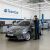 TeamCar szerelő szerel új ablaktörlő lapátokat egy szürke Toyota Corolla E18 szedánra egy szerviz műhelyben, demonstrálva a professzionális telepítést.