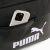 Közelkép okostelefonról a fekete Puma Campus Medium táska elülső zsebében, Puma logóval
