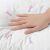Párnára nyomó kéz közelképe, illusztrálva a puha és kényelmes textúrát