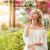 Nő élvezi a természetet pillangóval az orrán, illusztrálva a K&F Concept C Series White Mist Cinematic Effect szűrő hatását