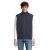 Elölnézet a FALCON BW MEN BODYWARMER-ről sötétkék színben, mosolygós férfin viselve fehér hosszú ujjú ingre és farmerre. A softshell mellény teljes cipzárral és több cipzáras zsebbel rendelkezik.