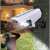 Solar powered motion sensor security light with fake camera design, illuminating a person in the dark