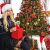 Woman with gift in front of decorated Springos artificial Christmas tree