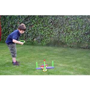 Kind spielt Ringwurfspiel im Freien, bunte Plastikringe und Stangen, Outdoor-Spiel für Kinder - Outdoor Spiele