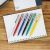 Selection of Schneider K15 ballpoint pens on notebook, multiple colors