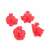 Set of 4 red plastic cookie cutters with spring-loaded plungers, featuring gingerbread man, snowflake, Santa Claus, and Christmas tree shapes