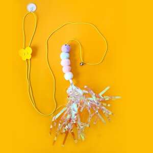 Rainbow cat toy with pom poms and a bell, hanging from a yellow string with a suction cup - Cat Toy