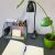 Izoxis clip-on desk lamp in use on a desk with stationery and a plant.