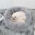 White cat sleeping in a grey fluffy dog bed