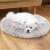 Small white dog sleeping in a grey fluffy dog bed