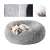 Grey plush dog bed with a dog sleeping in it, showing the soft fur and the raised edges