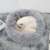 Grey plush dog bed with a cat sleeping in it, showing the soft fur and the raised edges