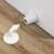 White door stop and holder with adhesive base on wooden floor
