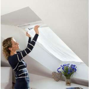 Woman installing a self-adhesive window mosquito net on a skylight window - Mosquito Net