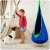 Child playing with a dog near a NeoSport single hanging swing, blue with green trim